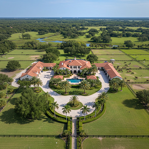 Aerial drone photography of a luxury Mediterranean-style mansion with a pool and sprawling green acreage in Gainesville, Florida, by PrimePropertyPhoto.