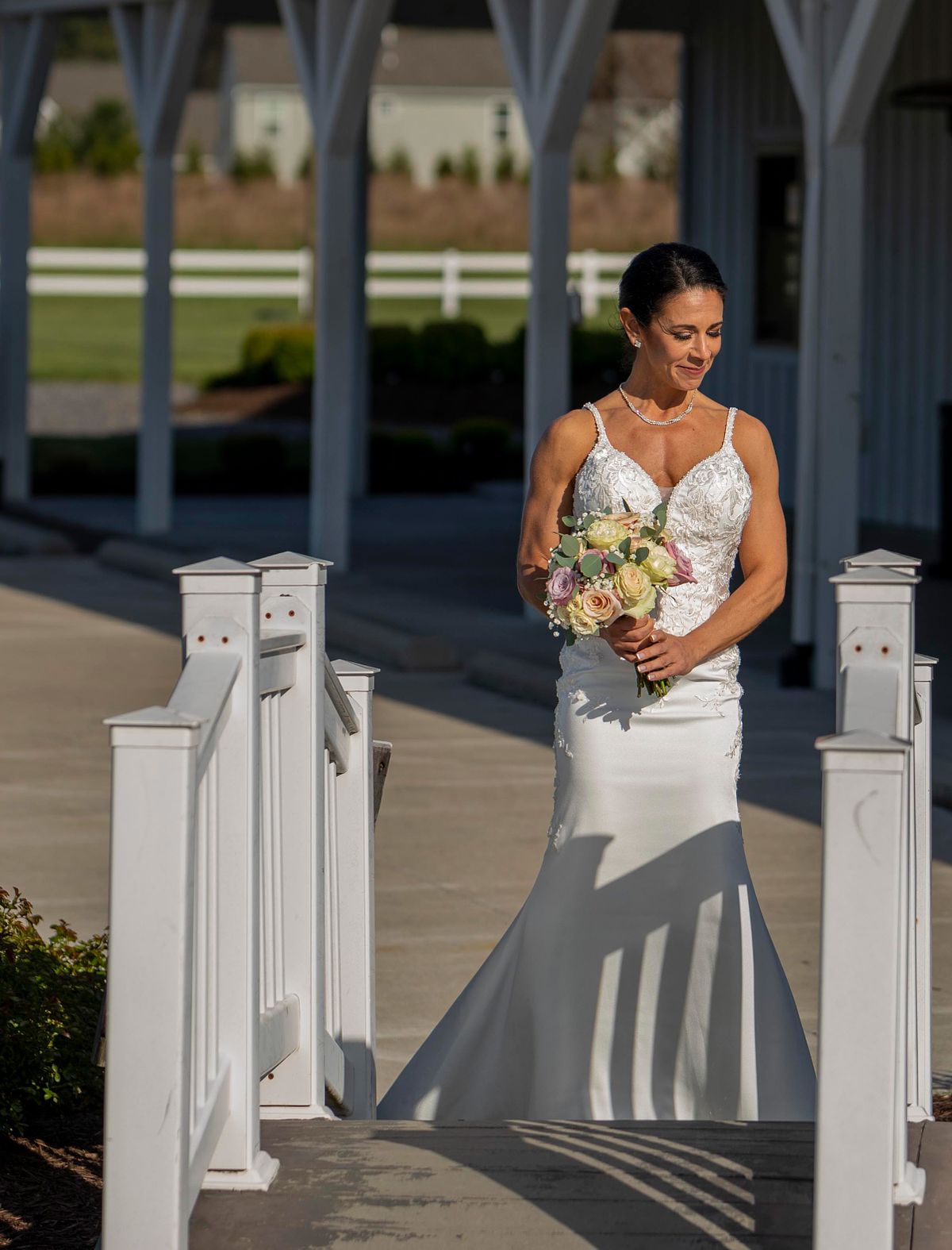 bride walking over the bridge at kylan barn to go to the wedding ceremony