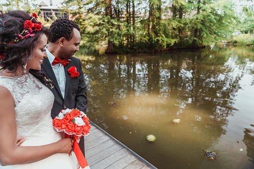 Bride and groom embracing at the turtle pond at the Fayetteville Botanical Gardens, photographed by a Raeford NC editorial luxury wedding photographer.