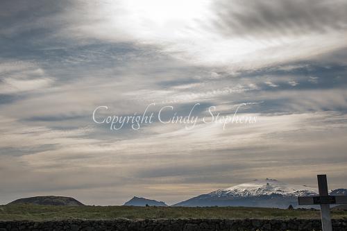 Grave marker with snow-covered mountains in the distance