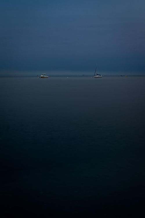 Plan d’eau sombre sous ciel uniforme.