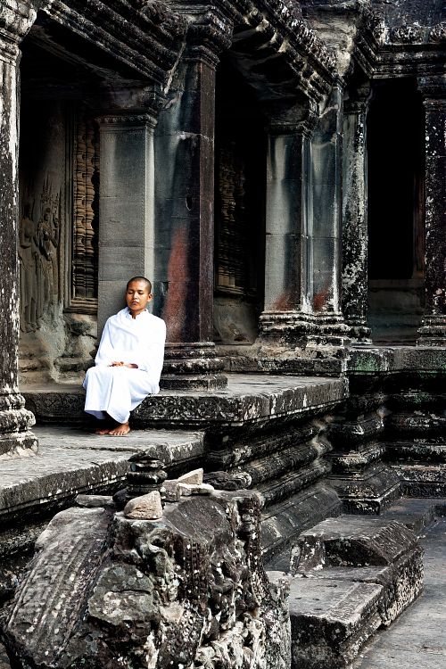 Portrait d'une jeune femme en méditation dans le temple d'Angkor au Cambodge