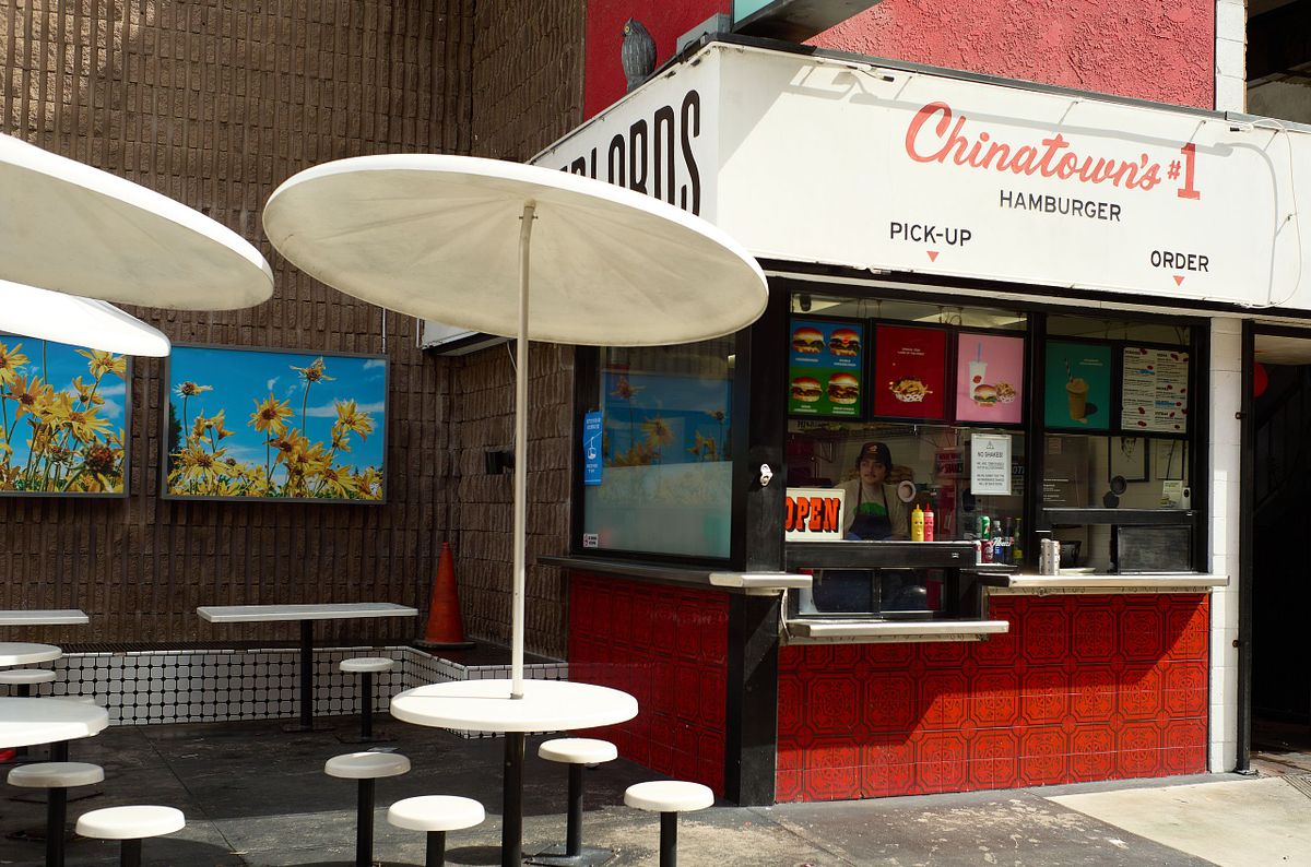 Relaxed afternoon at a hamburger stand in Chinatown, LA with white tables and umbrellas, captured by photographer Sandeep Gajula