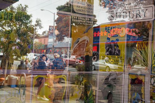 Reflections of the Haight-Ashbury neighborhood, featuring Beatles and Grateful Dead posters in a storefront, highlighting cultural identities in San Francisco.