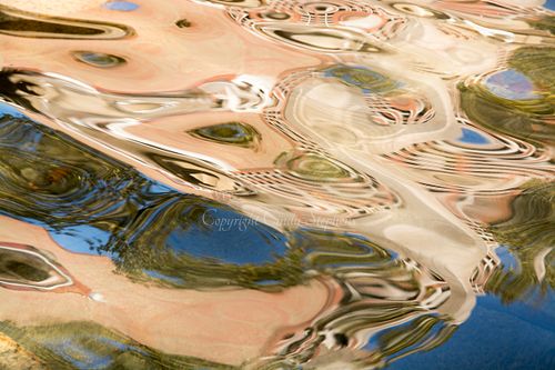 Abstract photograph featuring fluid, swirling patterns of azure, peach, and green that create a mesmerizing rhythm, inviting contemplation and evoking the beauty of peacock feathers
