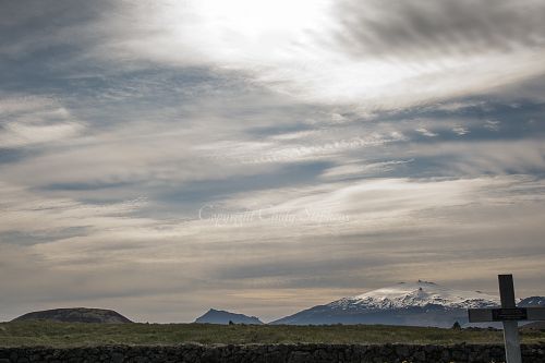 Grave marker with snow-covered mountains in the distance