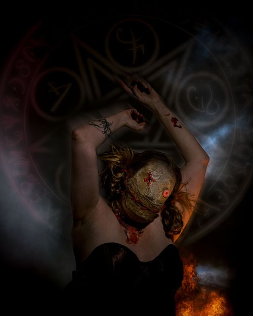 A voodoo doll raises her arms in front of an arcane circle.