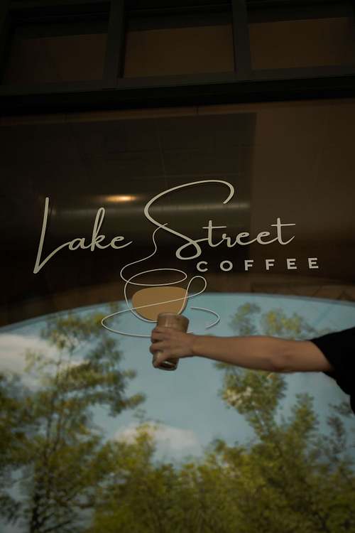 Lake Street Coffee sign displayed on a café window with reflections outside