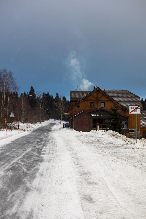 Route enneigée bordée d’arbres.