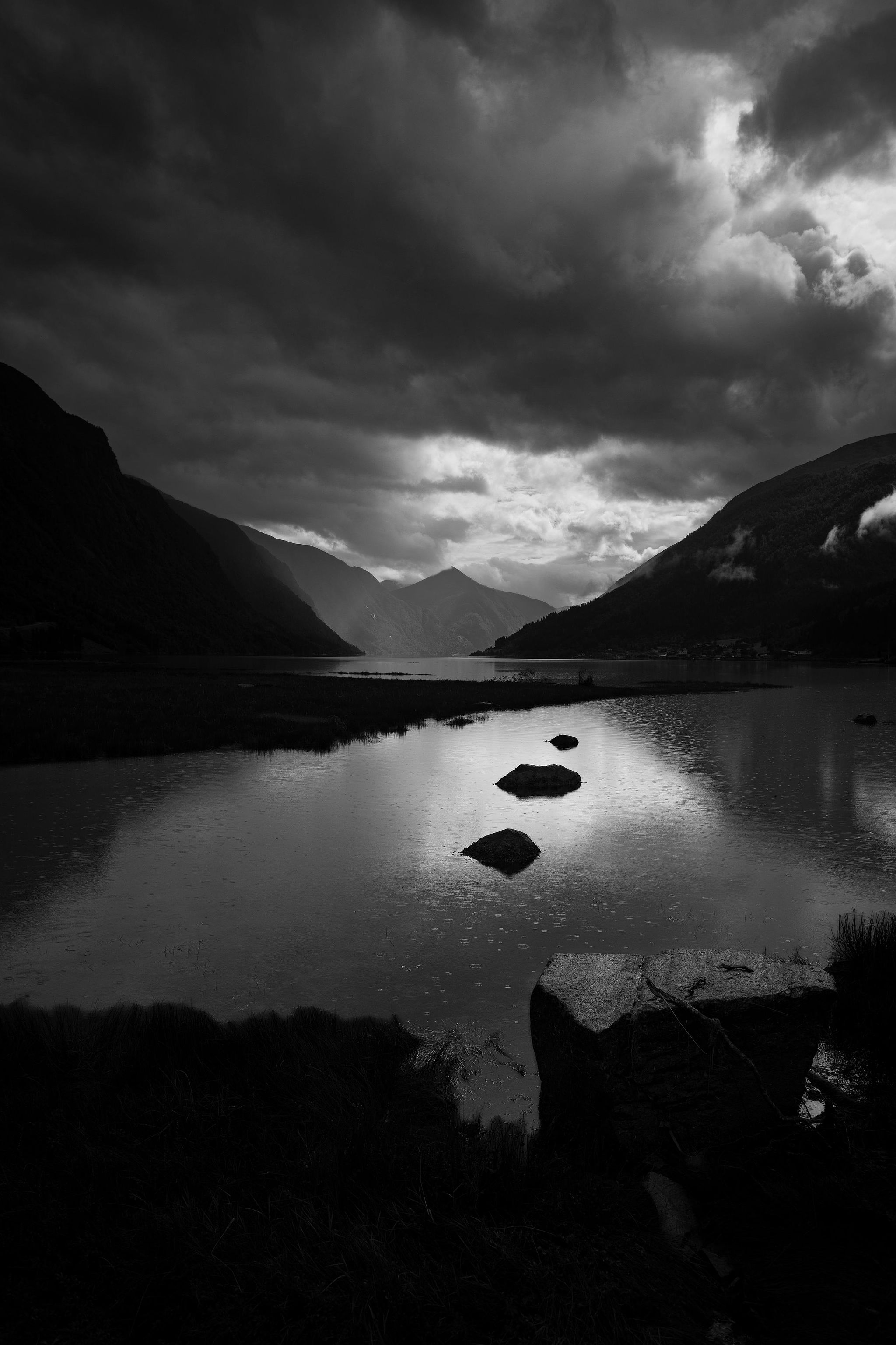 Vue minimaliste d'un fjord en noir et blanc.
