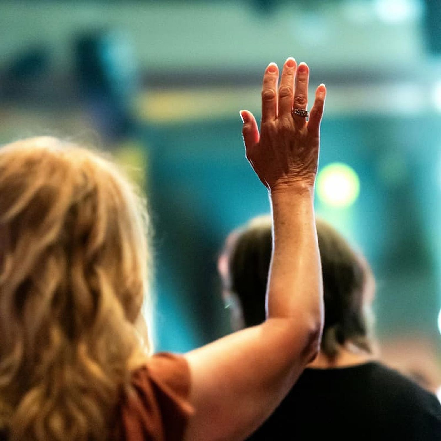 woman with hand raised in audience