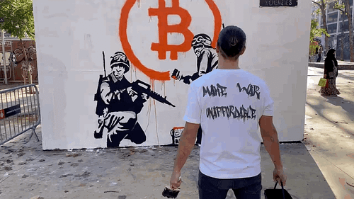 Animated GIF showcasing the creation of the Street Cyber "Make War Unaffordable" mural. Two stencil soldiers are depicted, one with a gun, the other painting a large, dripping orange Bitcoin symbol. The artist stands in front with a 'Make War Unaffordable' t-shirt. A pigeon flies by as the camera zooms in, symbolizing peace through action. This pivotal artwork marks the beginning of the Street Cyber movement.