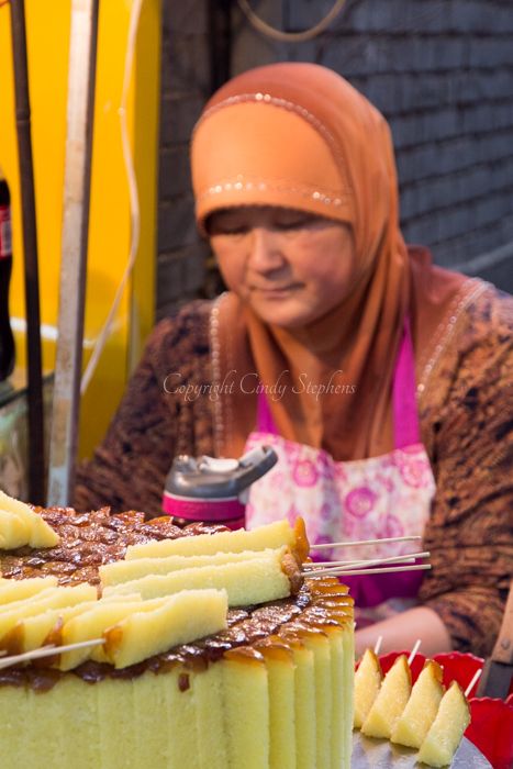 Female street vendor selling pineapple on a stick