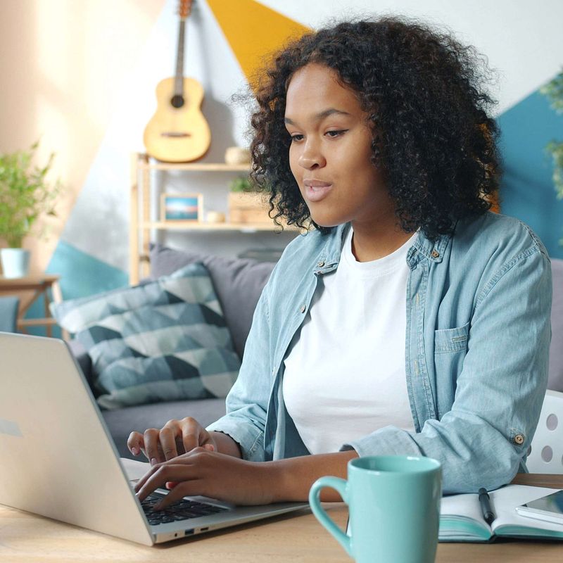 Perimenopausal woman researching menopause products on laptop at home