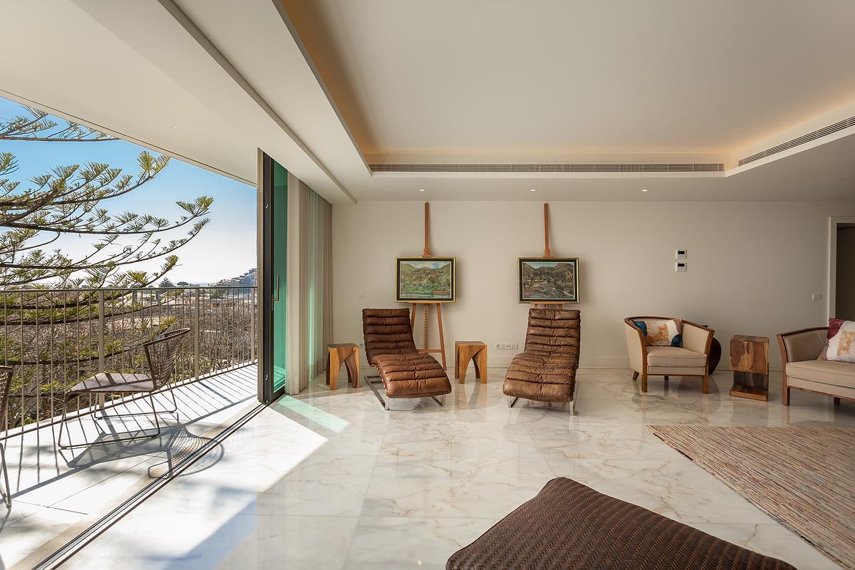 Sala de apartamento de luxo no Legacy Residences Cascais com liga&ccedil;&atilde;o &agrave; varanda e vista mar