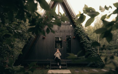 A-frame cabin surrounded by trees and soft natural light