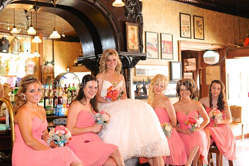 A bride and her bridesmaids sit on a bar at the Saloon #10 in Deadwood South Dakota