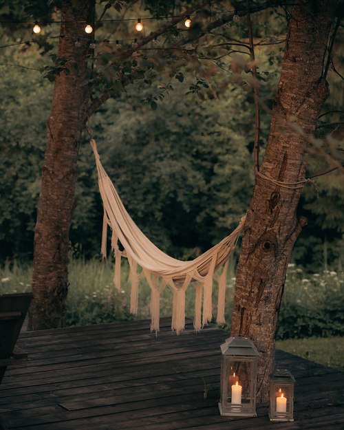 Hammock and lantern in a quiet forest near a cabin