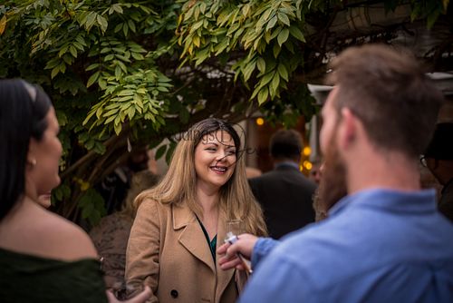 A group of friends gathered and chatting during the wedding reception, enjoying the celebration together, captured by Weddings By Jermaine.