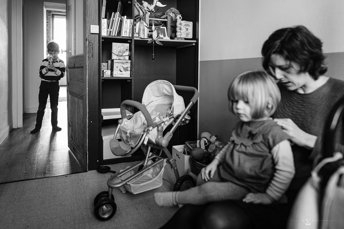 Photographe Famille Lyon Reportage Documentaire Famille Lyon - Enfant photographiant sa s&oelig;ur et sa maman dans un couloir pendant une s&eacute;ance photo de famille &agrave; Lyon