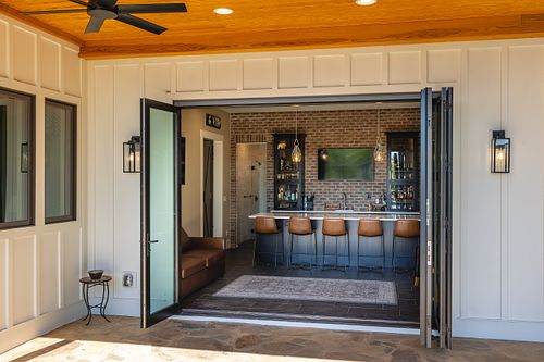 Glass bifold wall with swing door panel at the end