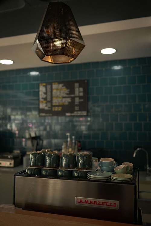 Coffee counter with cups, menu board, and tiled wall inside an independent café