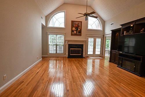 Spacious living room featuring wood floors and large windows