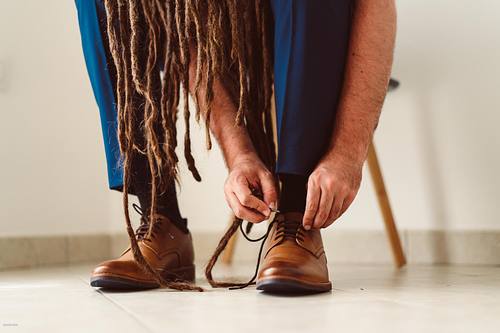 "sposo che si allaccia le scarpe visto dal basso"