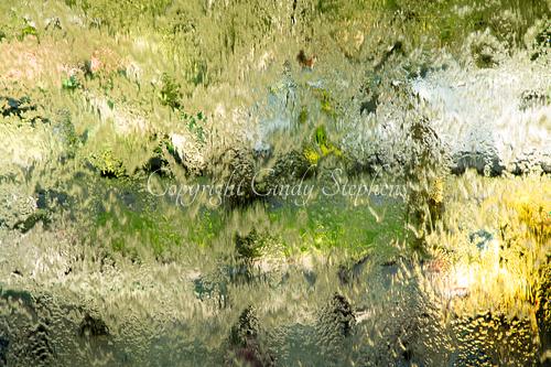 Captivating abstract photograph rich in vibrant greens and blues, reminiscent of watercolor fluidity, blending energy and tranquility while showcasing the artist's preservation of natural beauty