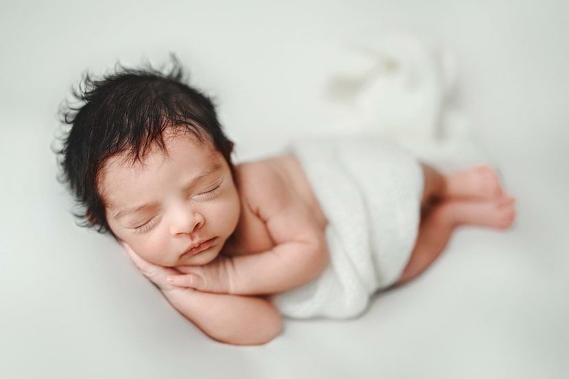 Sweet baby boy posed on a blanket sleeping