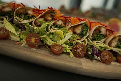 Freshly prepared café food served on a wooden board with colourful toppings