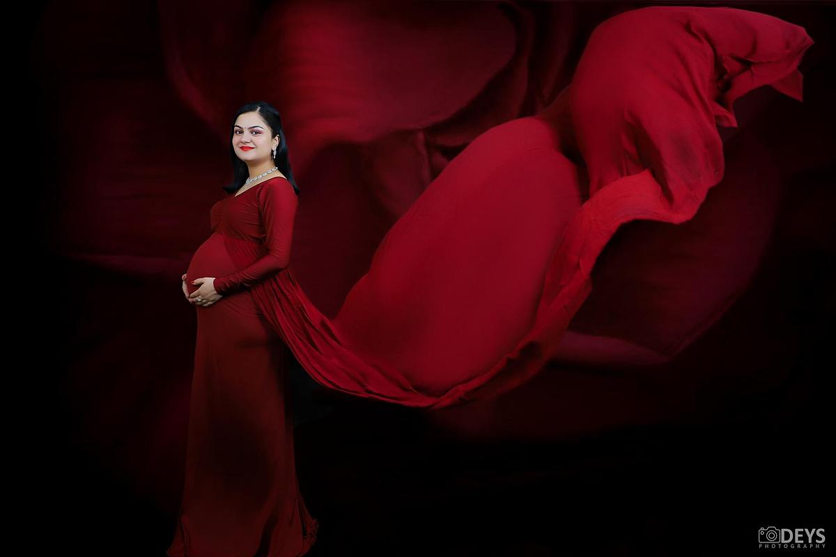 Red gown studio maternity photos in Delhi