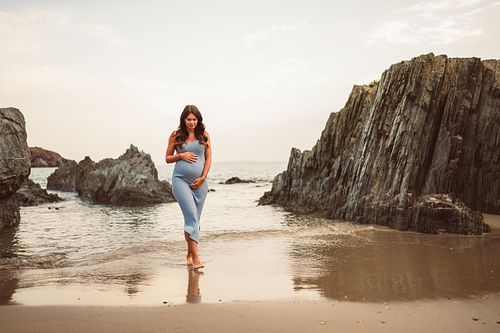 donna in gravidanza cammina nel bagnasciuga di Masua in Sardegna, Fotografo Gravidanza Cagliari Sud Sardegna
