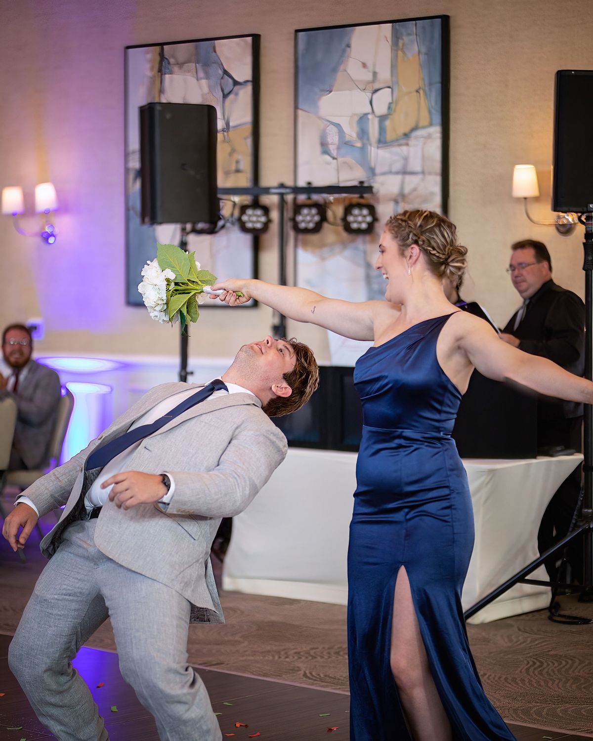 groomsmen and bridesmaid dancing during introduction at the hyatt in dewey beach, the groomsmen is wearing a grey suite and the bridesmaid a blue off the shoulder dress.