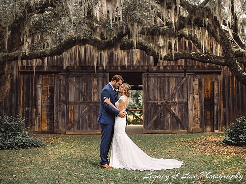 Couple's rustic barn ceremony under mossy oak trees in Marion County by Legacy of Love Photography.