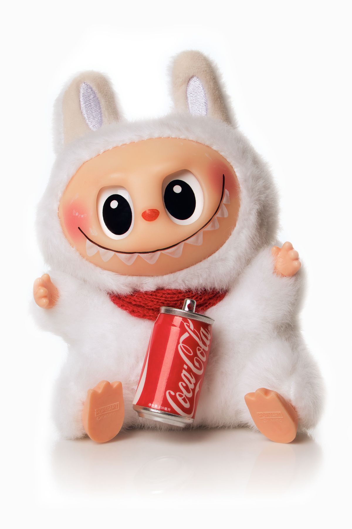 Red and white plush toy on a seamless white backdrop.