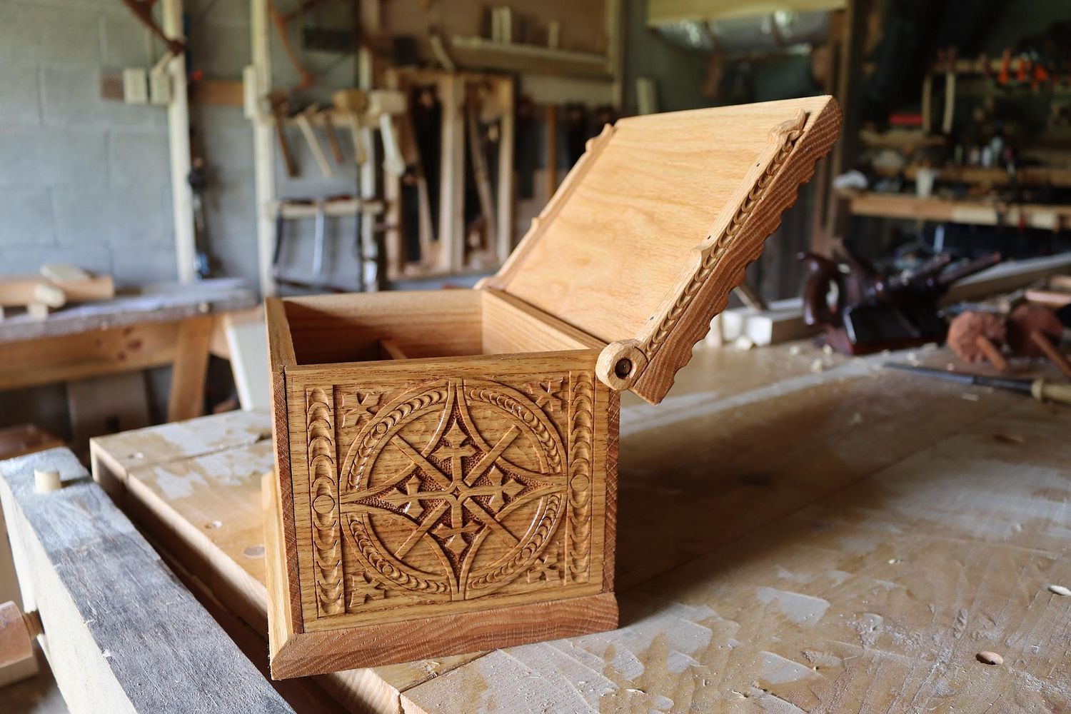 carved oak box with lid open showing how the wooden pintle hinges work