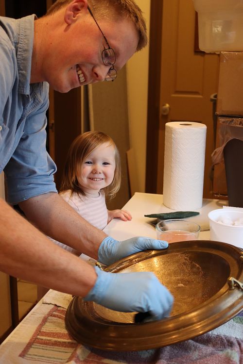 Wes Baker continues to polish the baptismal font while his daughter smiles