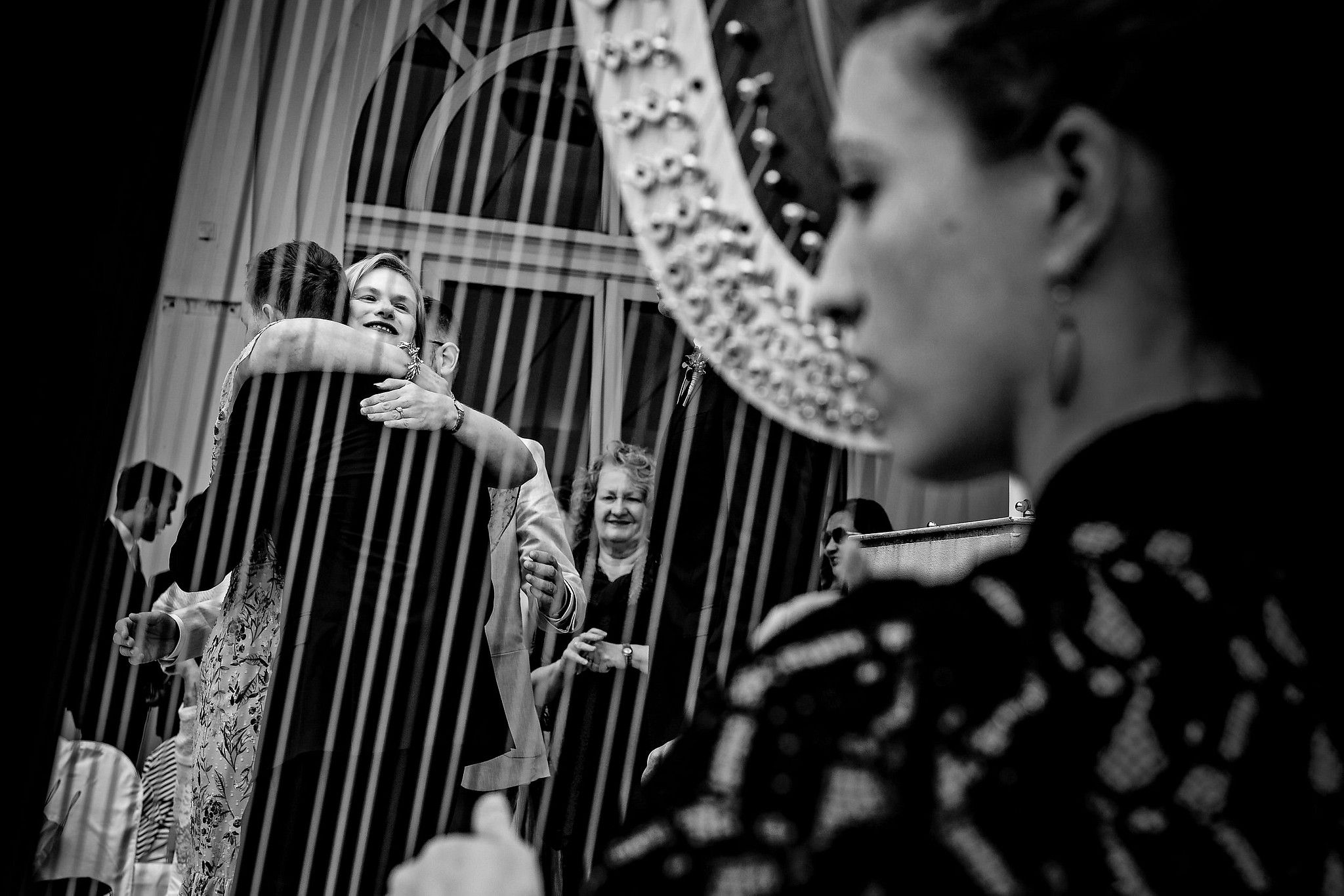 M&egrave;re du mari&eacute; qui l'embrasse tendrement pendant qu'une personne joue de la harpe captur&eacute; par S&eacute;bastien CLAVEL photographe de Mariage &agrave; Lyon et Gen&egrave;ve