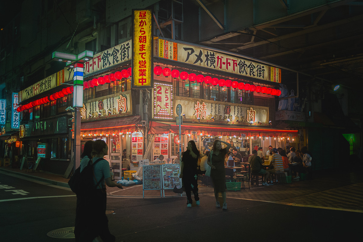 Marché Ameyoko sous les voies ferrées la nuit, enseigne géante et lanternes rouges