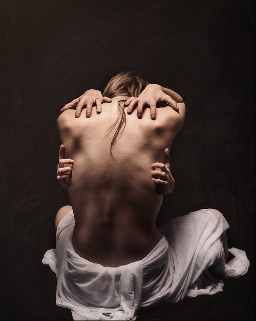 Photographie fine art d&rsquo;une femme nue vue de dos, retenue par quatre mains m&eacute;taphoriques, symbolisant un conflit int&eacute;rieur intense, des luttes mentales et &eacute;motionnelles &mdash; &oelig;uvre de Pascal Yennis, Namur, Belgique.