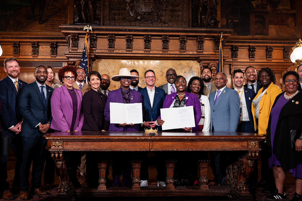 Large group of lawmakers, advocates, and community members gathered behind Governor Josh Shapiro for the CROWN Act signing at the Pennsylvania Capitol