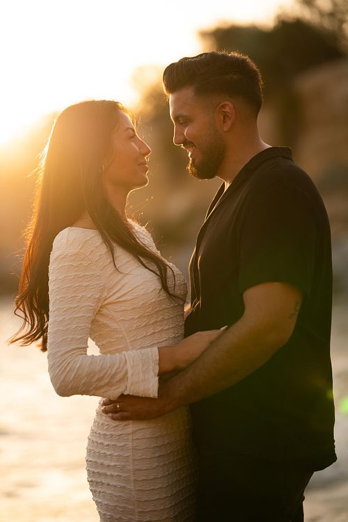 coppia innamorata si guarda in spiaggia al tramonto