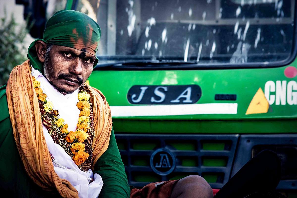 man, sadhu, garland, bus in background