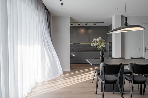 Mood photograph of living room with curtain gently blowing in the wind &ndash; Columna project