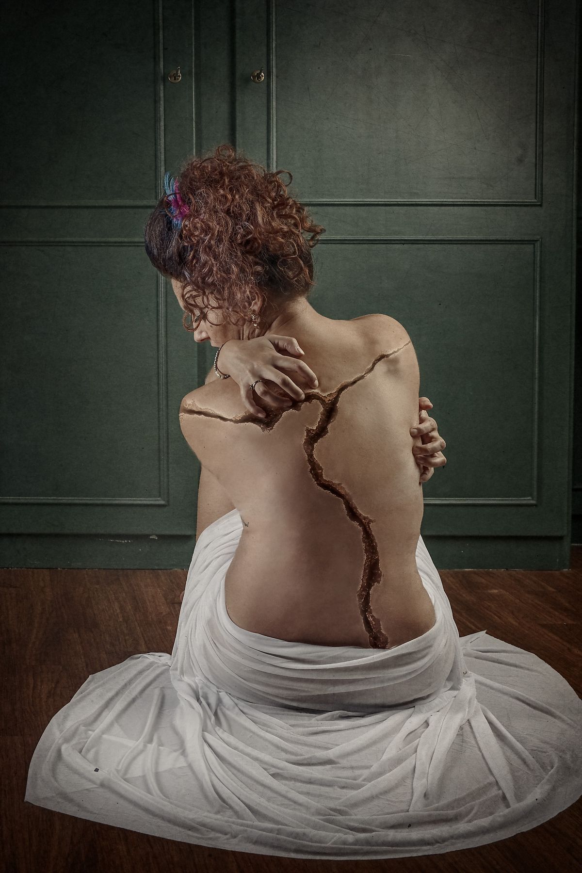 photo tarot Broken, femme vue de dos avec fissure dans le dos et regard baiss&eacute;, &eacute;voquant douleur et r&eacute;silience