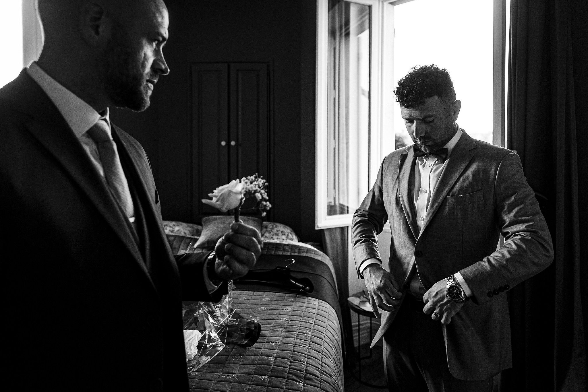 Fr&egrave;re du mari&eacute; qui se pr&eacute;pare sous le regard bienveillant de ce dernier captur&eacute; par S&eacute;bastien CLAVEL photographe de Mariage &agrave; Lyon et Gen&egrave;ve
