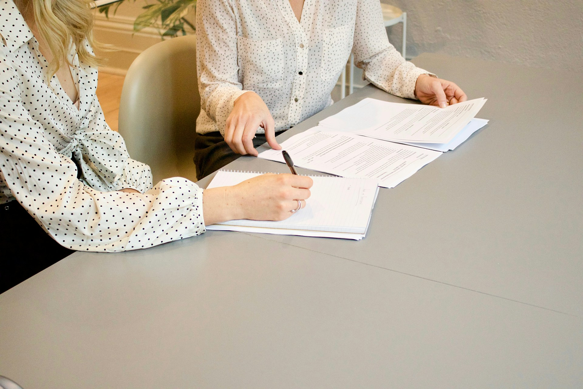 women signing business contracts during a negotiation