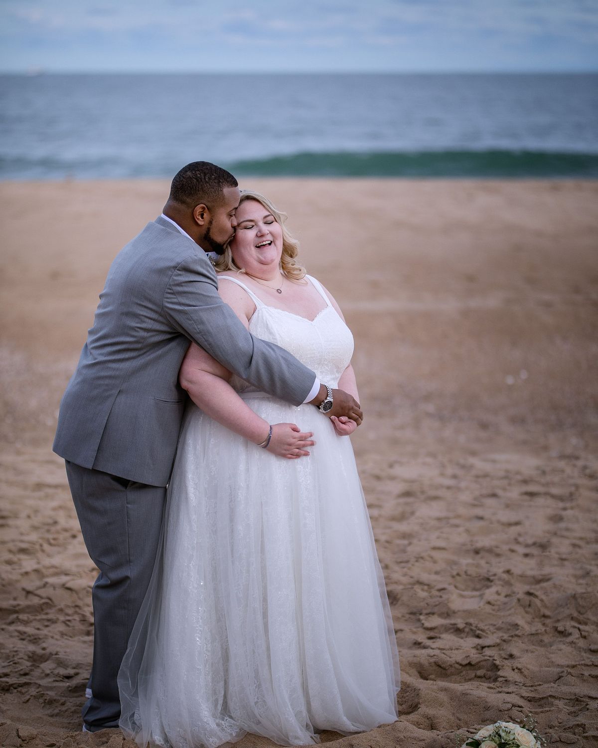 beach wedding at Golden Sands Ocean City with no crowds and perfect October weather, groom is hugging bride with her smiling